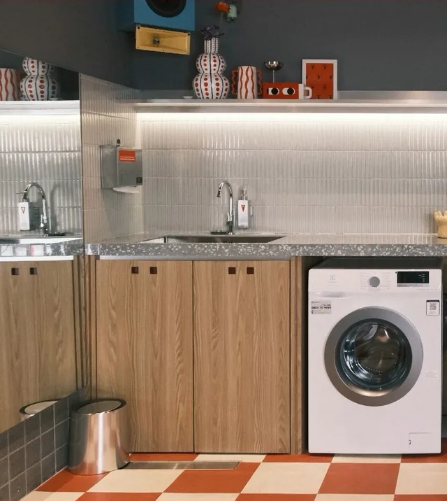 The self-service laundry room with a washing machine and a sink