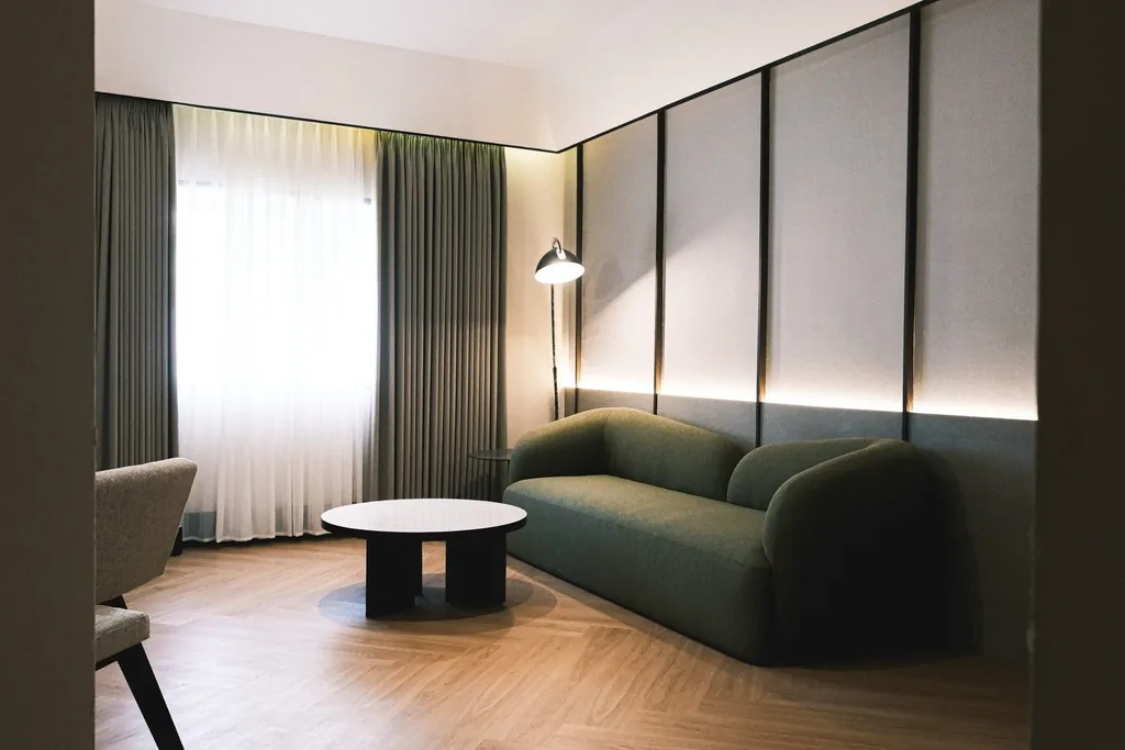 Suite living area with a green sofa and a round coffee table
