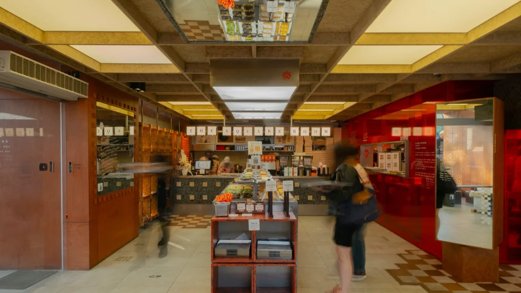 The bar at The Square Room under a wood-beamed ceiling, with a red glass corner on the right
