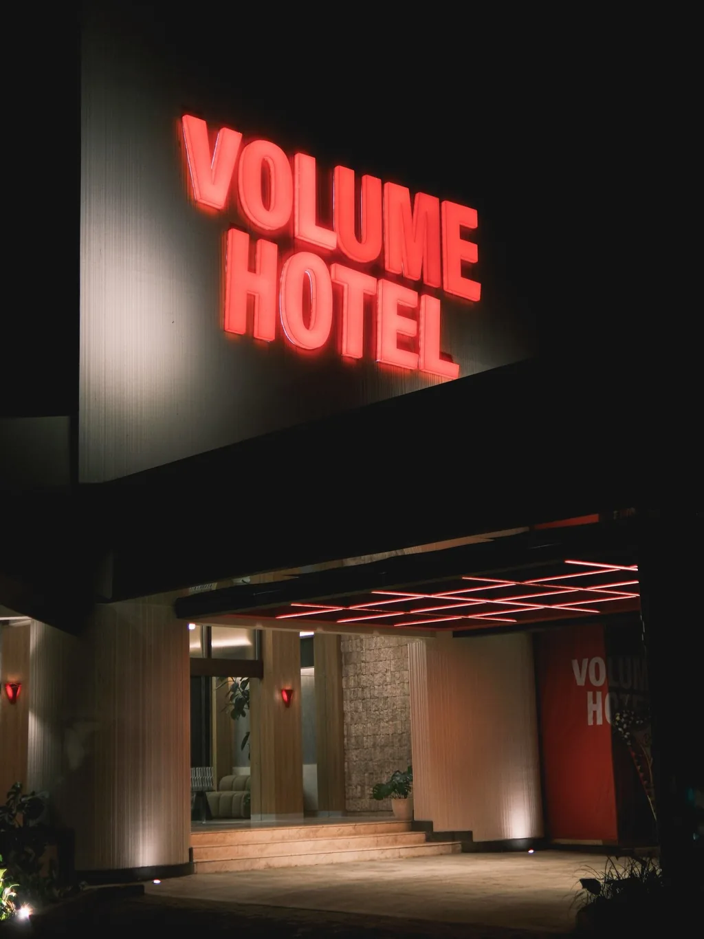 Volume Hotel entrance with the red neon sign at night