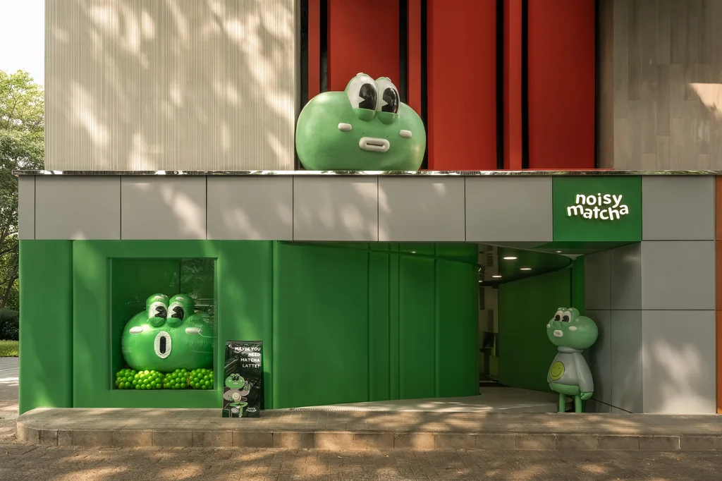 Noisy Matcha 2.0 facade in green and grey, with a large frog figure above the entrance and a smaller one beside the door